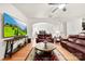 Bright living room featuring a ceiling fan, hardwood floors, and large television at 15916 Foreleigh Rd, Huntersville, NC 28078