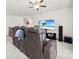 A spacious living area with a ceiling fan, large television, and comfortable leather seating at 15916 Foreleigh Rd, Huntersville, NC 28078