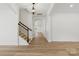 Bright foyer with hardwood floors, staircase with wrought iron railing, and elegant lighting fixture at 160 Belfry Loop, Mooresville, NC 28117