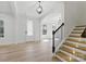 Bright, open-concept living space with hardwood floors, staircase, and elegant lighting at 160 Belfry Loop, Mooresville, NC 28117
