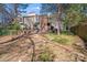 Spacious backyard with mature trees, brick accents, and privacy fence at 1606 Sharon W Rd, Charlotte, NC 28210