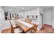 Open dining room featuring a large wood table, seating for six, modern lighting, and a mirrored accent wall at 1606 Sharon W Rd, Charlotte, NC 28210