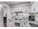 Bright kitchen boasts granite countertops, white cabinets, and modern appliances at 1606 Sharon W Rd, Charlotte, NC 28210