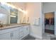 Bright bathroom with double sinks, granite countertops, and modern fixtures with walk-in closet access at 1638 Sweetmoss Loop, Denver, NC 28037
