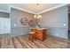 Elegant dining area with gray walls, white trim, a stylish light fixture, and wood-look laminate floors at 1638 Sweetmoss Loop, Denver, NC 28037