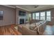 Spacious living room featuring a fireplace, large windows, wood-look laminate floors, and comfortable leather seating at 1638 Sweetmoss Loop, Denver, NC 28037