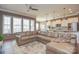 Bright living room with large windows, wood-look laminate floors, and comfortable leather seating that opens to the kitchen at 1638 Sweetmoss Loop, Denver, NC 28037