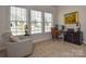 Comfortable office area with a chair and desk next to the natural light from the windows at 1638 Sweetmoss Loop, Denver, NC 28037