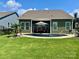 Backyard pool with an umbrella and lounge furniture surrounded by a green lawn and privacy fence at 1638 Sweetmoss Loop, Denver, NC 28037