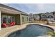 Beautiful in-ground pool with patio, red lounge furniture and attractive homes in the background at 1638 Sweetmoss Loop, Denver, NC 28037