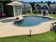 Backyard with a private pool, well-maintained lawn, and an umbrella for shaded relaxation at 1638 Sweetmoss Loop, Denver, NC 28037