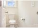 Bright bathroom featuring a white toilet, tile flooring, and a window providing natural light at 165 Winterberry St, Mooresville, NC 28117