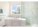 Bright bathroom featuring a soaking tub, glass shower and a large window providing natural light at 165 Winterberry St, Mooresville, NC 28117