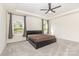 Spacious bedroom with plush carpeting, a modern ceiling fan, and natural light streaming through the windows at 165 Winterberry St, Mooresville, NC 28117