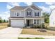 Charming two-story home featuring a two-car garage, stone accents, and a well-maintained front yard at 165 Winterberry St, Mooresville, NC 28117