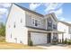 Side view of home featuring garage, white siding, well maintained lawn and a inviting front porch at 165 Winterberry St, Mooresville, NC 28117