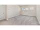 A versatile empty room with plush carpeting, neutral walls, and windows offering natural light at 165 Winterberry St, Mooresville, NC 28117