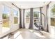 Inviting sun room with a modern hanging chair and multiple windows that let in an abundance of light at 165 Winterberry St, Mooresville, NC 28117