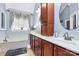Bright bathroom featuring dual sinks, a window, cherry cabinets, and a large tub at 1674 Wakefield Way, Rock Hill, SC 29730
