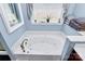 Bathroom featuring a large tub with tile surround, accompanied by a window at 1674 Wakefield Way, Rock Hill, SC 29730