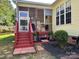 A home's screened-in sunroom with red painted stairs and black mulch at 1674 Wakefield Way, Rock Hill, SC 29730