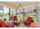 Beautiful screened-in porch with red trim, string lights, and cozy furniture at 1674 Wakefield Way, Rock Hill, SC 29730