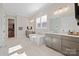 Bright bathroom featuring marble floors, a soaking tub, dual vanities, and stylish fixtures at 180 Twin Sisters Ln, Mooresville, NC 28117