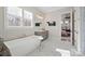 Bright bathroom featuring a soaking tub, double vanity, and a glimpse into the bedroom at 180 Twin Sisters Ln, Mooresville, NC 28117
