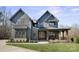 Stunning two-story home features a covered porch with timber columns and a beautifully landscaped front yard at 180 Twin Sisters Ln, Mooresville, NC 28117