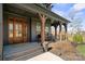 Inviting front porch with timber columns, seating area, and a beautiful solid wood front door at 180 Twin Sisters Ln, Mooresville, NC 28117