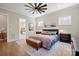 Comfortable main bedroom with a ceiling fan, stylish furniture, and a glimpse into the ensuite bathroom at 180 Twin Sisters Ln, Mooresville, NC 28117