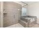 Modern bathroom with a glass-enclosed shower, soaking tub, and neutral gray tiling at 1854 Carrollton Dr, Indian Trail, NC 28079