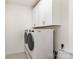 Neat laundry room with a white front-load washer and dryer, and white storage cabinets at 1854 Carrollton Dr, Indian Trail, NC 28079