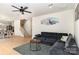 Open-concept living room features hardwood floors, a ceiling fan, and a cozy gray sofa at 1854 Carrollton Dr, Indian Trail, NC 28079