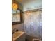 Cozy bathroom with vanity sink, tiled walls, and shower with decorative curtain at 203 S Washington St, Monroe, NC 28112