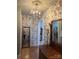 Charming hallway with floral wallpaper, hardwood floors, and vintage chandelier at 203 S Washington St, Monroe, NC 28112