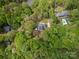 Aerial view of home surrounded by mature trees and a private pool at 207 Windsor Greene Dr, Monroe, NC 28110