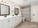 A bathroom with double sinks, white cabinets, and a shower and tub combo at 207 Windsor Greene Dr, Monroe, NC 28110