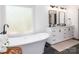Luxurious bathroom with dual vanities, modern lighting, a freestanding tub, and large window at 207 Windsor Greene Dr, Monroe, NC 28110