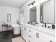 Elegant bathroom with dual vanities, modern lighting, a freestanding tub, and black tile floors at 207 Windsor Greene Dr, Monroe, NC 28110