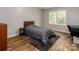 This bedroom features wood floors, gray bedding and an outside view through the window at 207 Windsor Greene Dr, Monroe, NC 28110