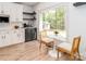 Cozy breakfast nook with a bistro table, chairs, and a scenic view from the large window at 207 Windsor Greene Dr, Monroe, NC 28110