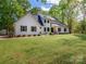 Charming white brick home with brown shutters and lush green lawn, surrounded by mature trees at 207 Windsor Greene Dr, Monroe, NC 28110