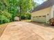 Large garage with a spacious driveway, surrounded by lush greenery at 207 Windsor Greene Dr, Monroe, NC 28110
