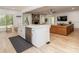 Kitchen island with sink and dishwasher opens to a living room with fireplace and leather sofa at 207 Windsor Greene Dr, Monroe, NC 28110