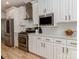 Elegant kitchen with stainless steel appliances, white cabinets, and a stylish range hood at 207 Windsor Greene Dr, Monroe, NC 28110