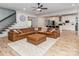 Open concept living room with staircase, kitchen, and leather sectional sofa on a patterned rug at 207 Windsor Greene Dr, Monroe, NC 28110