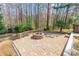 Backyard view of a brick fire pit with trees surrounding the outdoor space at 2243 Creek View Ct, Indian Land, SC 29707