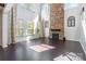 Bright living room featuring a floor-to-ceiling stone fireplace, hardwood floors, and large windows at 2243 Creek View Ct, Indian Land, SC 29707