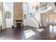Bright living room with stone fireplace, open staircase, and hardwood floors leading to other living spaces at 2243 Creek View Ct, Indian Land, SC 29707